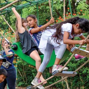 Children climbing and swinging on modern dome playground at the Honolulu Zoo