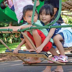 Children swinging on playground equipment at the Honolulu Zoo