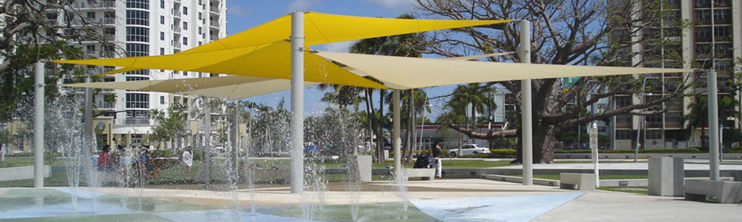 Shade structures for splash parks with sail features